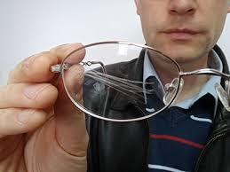 man holding scratched glasses