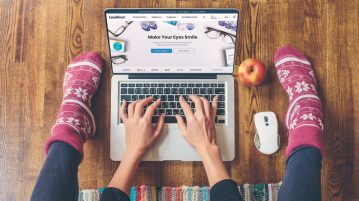buying contact lenses online girl with feet showing typing on computer