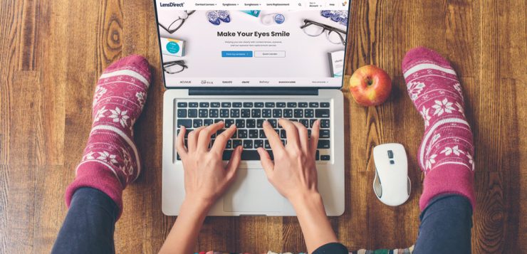 buying contact lenses online girl with feet showing typing on computer
