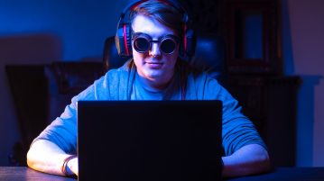 late night gamer with goggles on for blue light protection