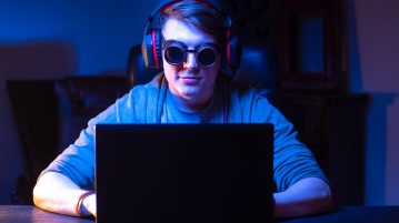 Do Gaming Glasses Actually Work? Are They Worth It? late night gamer with goggles on for blue light protection