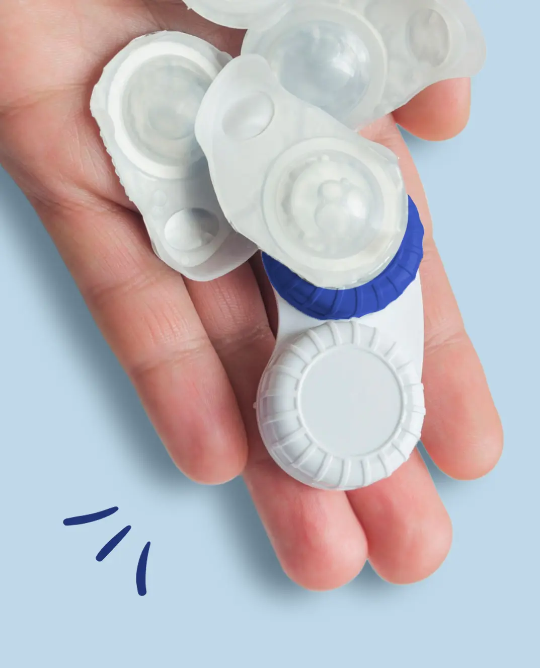 Close-up of a hand holding contact lens blister packs and a storage case, illustrating the difference between daily and monthly contacts.