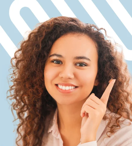 Smiling woman pointing upward against a light blue background with white graphic lines.