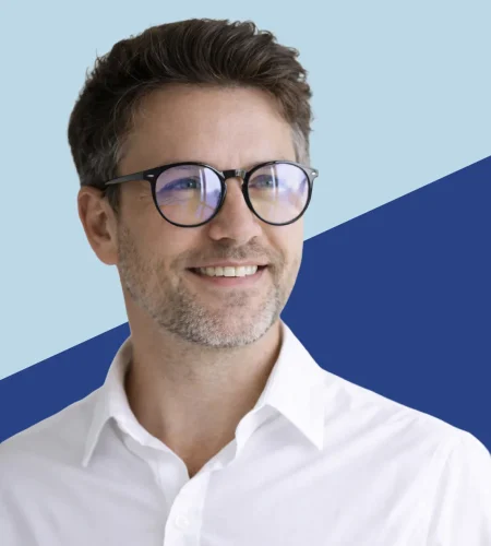 Man wearing eyeglasses with reflective lenses, representing comparison of anti-reflective coating vs blue light lenses.