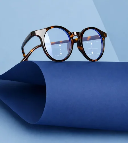 Close-up of eyeglasses on a curved surface with measurement markings, illustrating how to measure segment height for lenses at home.